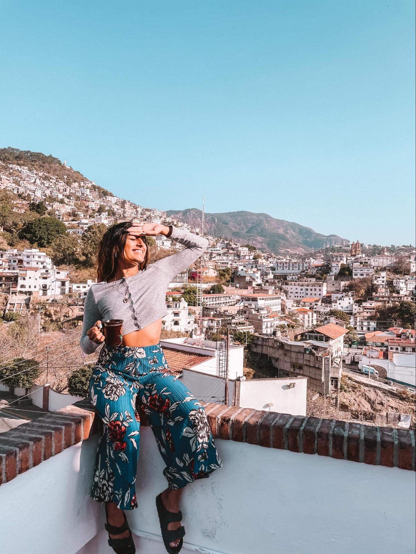 Nabila Ismail sits facing the bright morning sun with a cup of coffee in hand